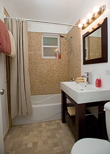 white bathtub with shower head and brown shower curtain, white sink top and waterfall faucet