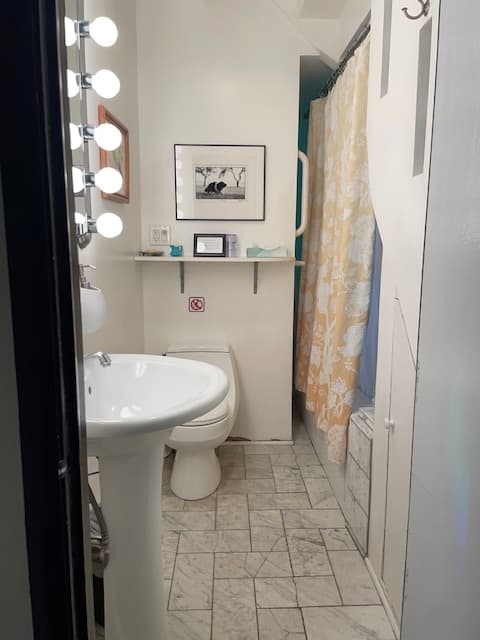 bathroom with white sink, toilet, whirlpool tub and white marble floor tile.