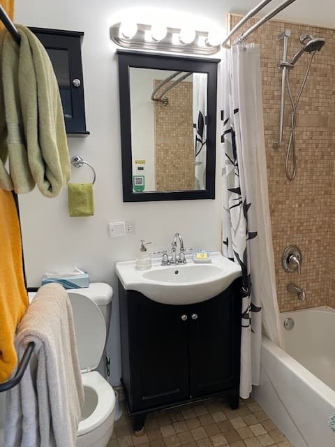 white bathtub, white sink top dark wood base and white ceramic toilet