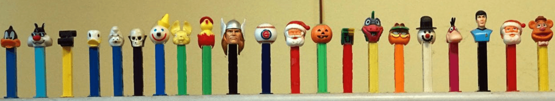 A colorful array of PEZ dispensers with various cartoon and character heads.